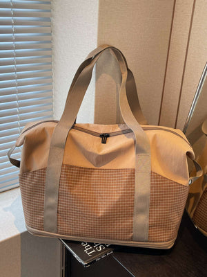 Spacious nylon travel duffel bag in khaki with grid pattern detail and dual handles.