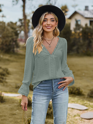 Sage green textured blouse with lace trim V-neck and bell sleeves.