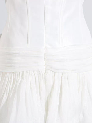 White mini dress with ruched bodice and tiered ruffled skirt.