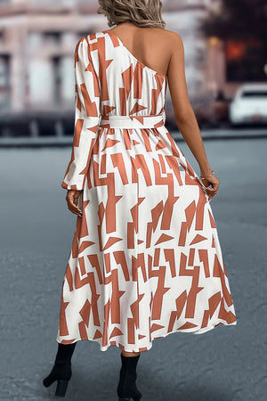 Geometric print asymmetric maxi dress with belt in cream and rust, one long sleeve, one sleeveless.