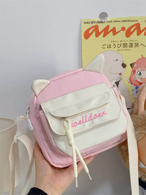 Pink and white crossbody bag with cat ears and embroidered text