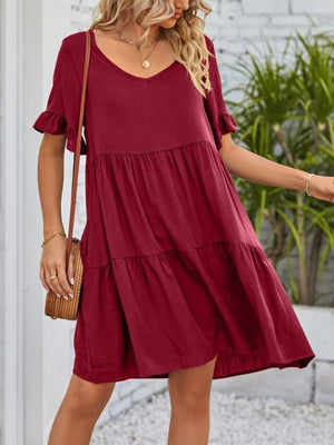 Burgundy tiered mini dress with ruffled sleeves and V-neck.
