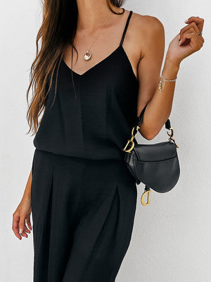 Black pleated palazzo pants and cami set with gold hardware bag.