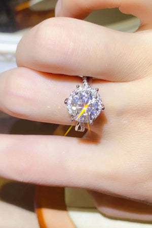 Silver moissanite halo engagement ring with a twisted band.