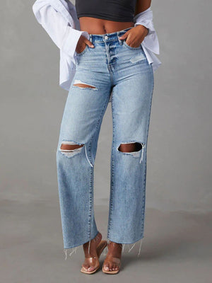 Light wash denim wide leg jeans with distressed knee rips and frayed hem