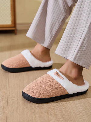 Cable knit shearling house slippers in tan with white trim and a wooden button detail.