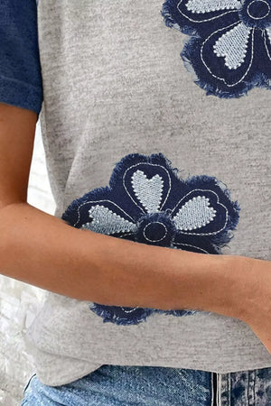 Grey t-shirt with denim floral appliques and blue sleeves.