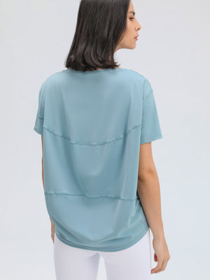 Dusty blue relaxed fit performance tee with horizontal seam details on back.