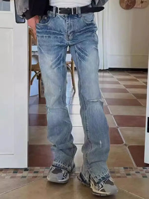 Medium wash denim jeans with distressed details and split hems