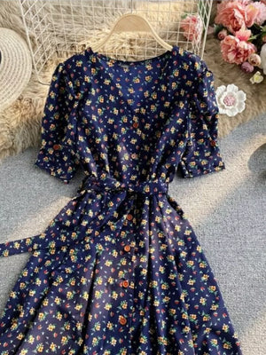 Dark blue floral v-neck midi dress with button front and belted waist.