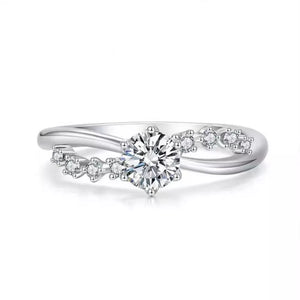 Sterling silver ring with a central round-cut zircon and smaller accent stones on a curved band.