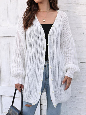 White balloon sleeve cardigan with pearl buttons and open knit detail.
