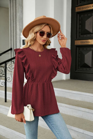 Textured ruffle peplum blouse in wine with long sleeves and cinched waist.