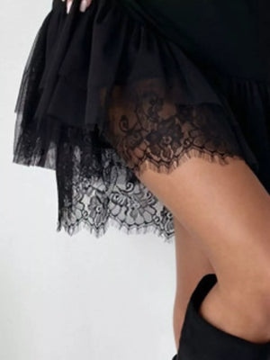 Black mini dress with lace-trimmed tulle hem and ruffled layers.