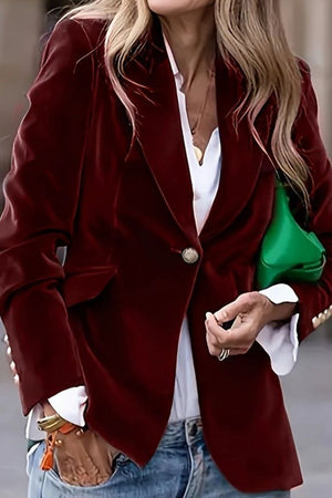 Burgundy velvet blazer jacket with single button closure and flap pocket detail.