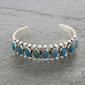 Turquoise cabochon open bangle bracelet with silver alloy detailing