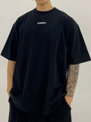 Black oversized t-shirt with white VETEMENTS logo on chest.