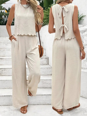 Cream linen lounge set with scalloped hem top and backless bow detail, wide leg pants.