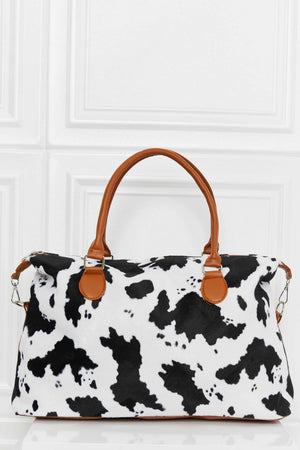 Satchel bag with cow print, brown leatherette handles and trim.