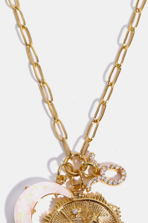 Gold celestial zodiac pendant necklace with moon and sun charms, and a diamond-encrusted zodiac symbol.