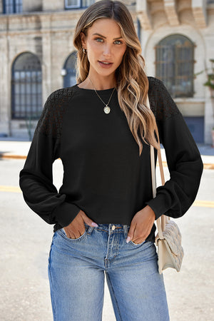 Black waffle knit raglan top with lace yoke detail and balloon sleeves.