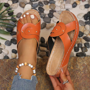 Orange embellished open-toe wedge sandals with decorative straps and gold studs.