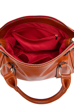 Caramel structured satchel bag interior with red lining, zip pocket, and multiple compartments.