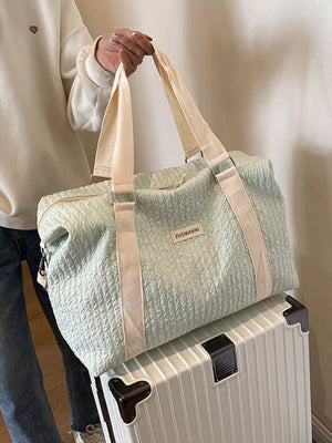 Textured travel bag with cream straps and a detachable pouch.