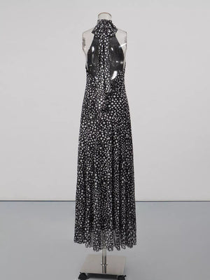 Black and white polka dot halter maxi dress with a flowing skirt and open back.