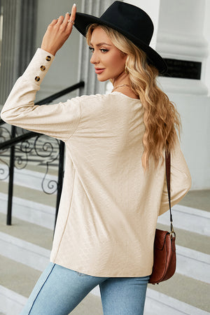 Cream diamond-textured V-neck blouse with button cuff detail
