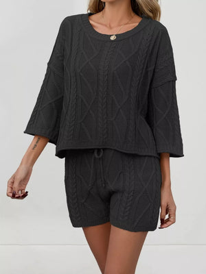 Black cable-knit two-piece sweater set with crew neck and drawstring shorts.