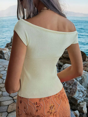 Yellow off-shoulder knit top with short sleeves and ribbed detail.