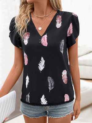 Black blouse with feather print, V-neck, and puff sleeves.