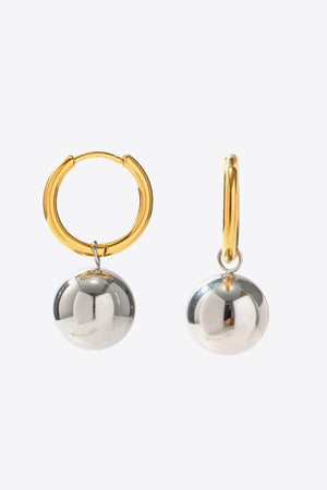 Orbital gold and silver drop earrings with large spherical charms.