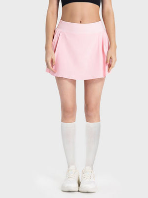 Pleated performance mini skirt in blush pink with a flared hem.