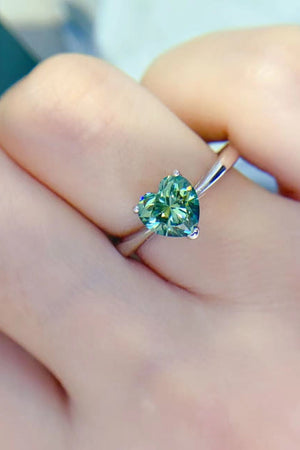 Green heart moissanite solitaire ring on a finger