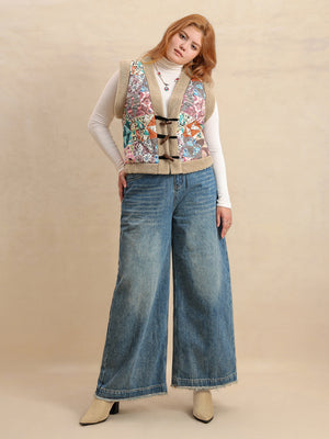 Patchwork sherpa toggle vest with multicolor geometric pattern and tan trim, worn open over a white turtleneck and wide leg