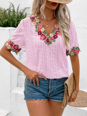 Blush pink eyelet peasant blouse with floral embroidery on V-neck and sleeves.