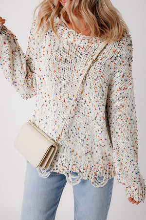 White confetti knit sweater with distressed hem and colorful flecks.
