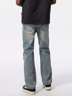 Men's light wash wide-leg jeans with distressed details and moto-inspired stitching.