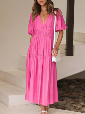 Hot pink midi dress with puff sleeves, V-neck, smocked waist, and tiered skirt.