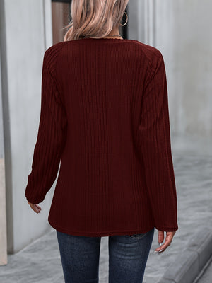 Burgundy ribbed knit raglan sweater with button trim detail.
