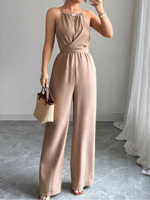 Halter neck wide leg jumpsuit in beige with a drawstring waist and wrap detail.