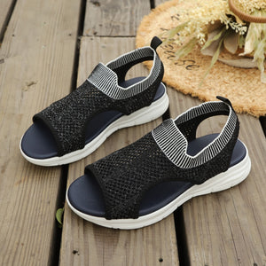 Black open-toe sandals with white striped ankle cuff and breathable knit upper.
