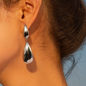 Silver teardrop dangle earrings with a high-shine finish.