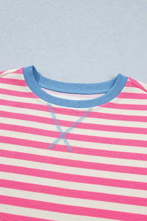 Short sleeve tee with pink and white stripes, blue neckline, and contrast stitching detail.