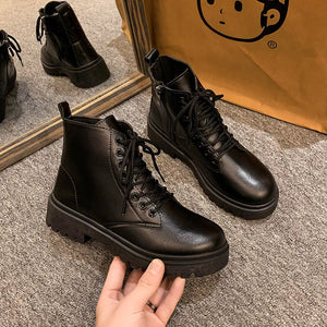Black glossy leather combat booties with lace-up and side zip detail.