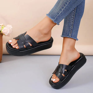Black leather platform caged slides with woven straps.