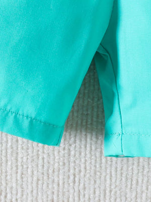 Baby set in multicolor teal and turquoise cotton, showing garment seams and hem detail.