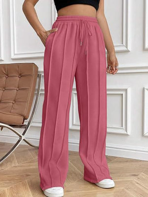 Deep Rose pleated wide-leg lounge trousers with drawstring waist and pockets.